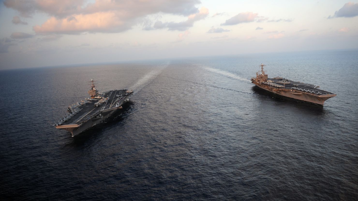 The USS Abraham Lincoln, at left with the John Stennis in the Arabian Sea, moved through the Strait of Hormuz on Sunday.