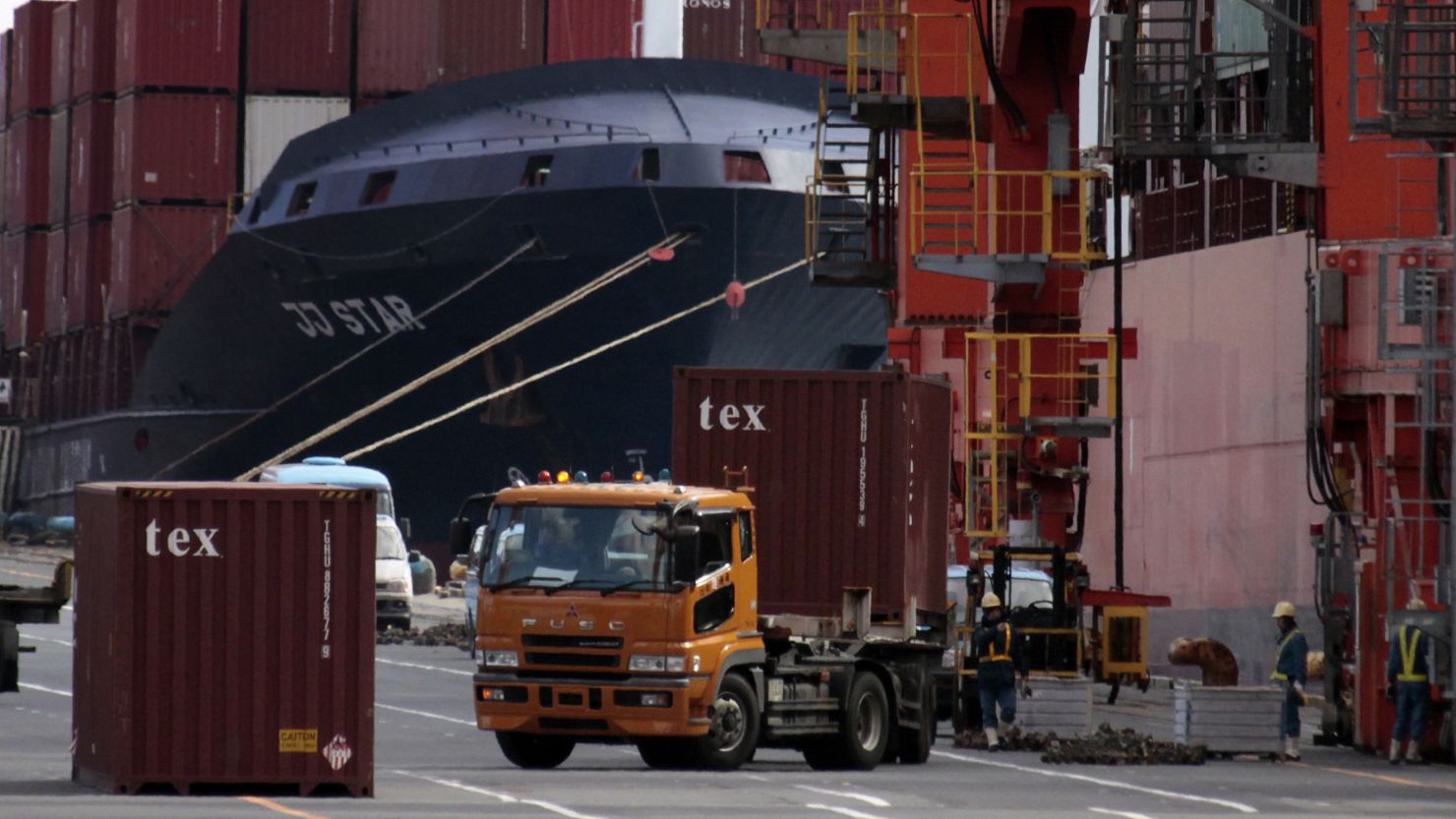 Containers are loaded and unloaded from a container vessel at a Tokyo port in this 2011 file photo.