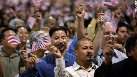 Immigrants wave flags after being sworn in as U.S. citizens in naturalization ceremonies in Pomona, California.
