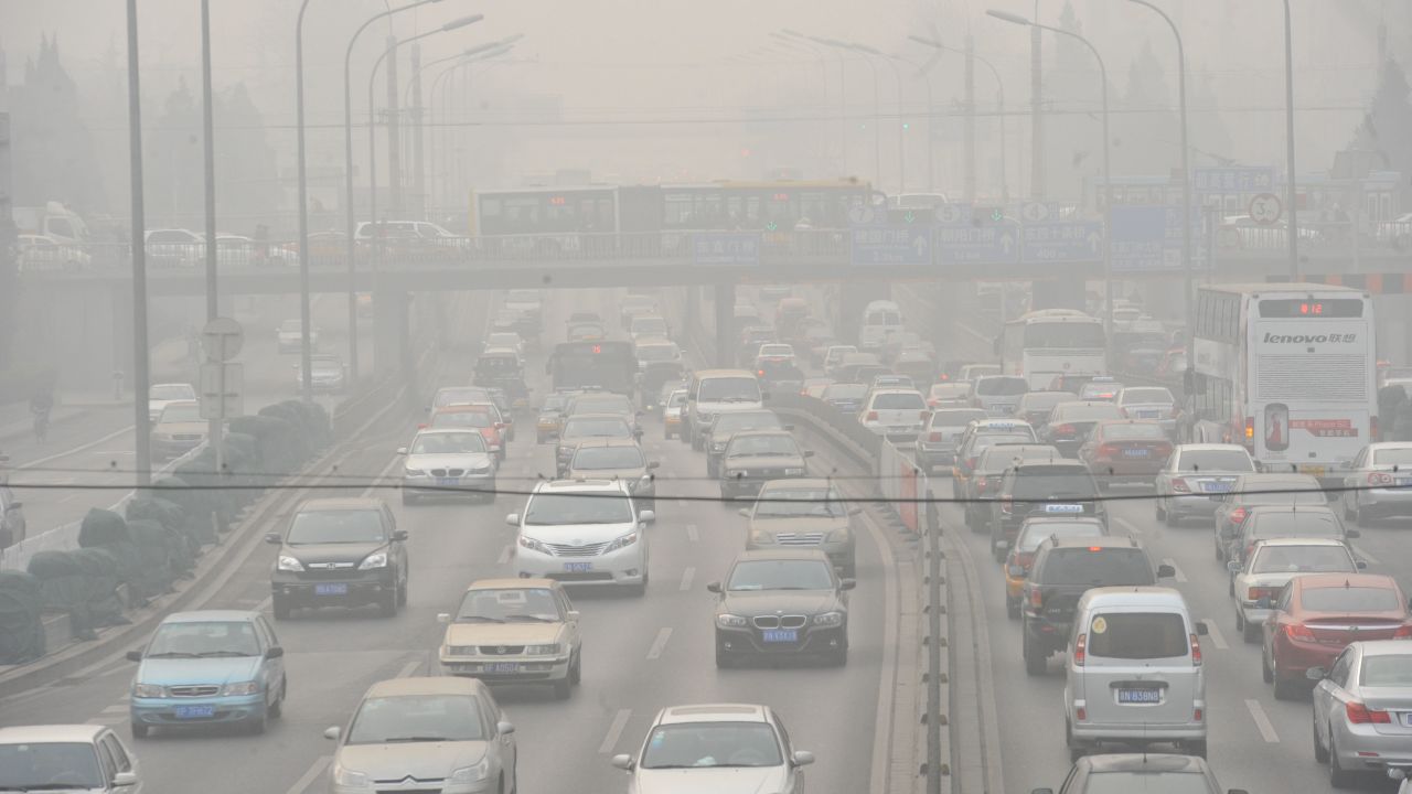 Vehicles make their way along a road on a smoggy day in Beijing on January 18.