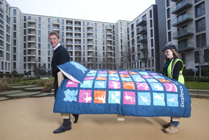 British rowing legend Matthew Pinsent helps lift in the first of 16,000 beds to be installed in London's Olympic Village on January 26, 2012.