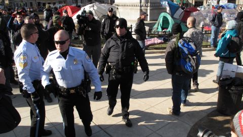 Police walk through the McPherson Square camp of  Occupy DC on Monday. Demonstrators greeted them with jeers and taunts.