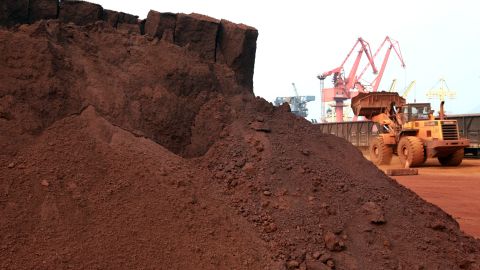 In a picture taken on September 5, 2010 a man driving a front loader shifts soil containing rare earth minerals to be loaded at a port in Lianyungang, east China's Jiangsu province, for export .