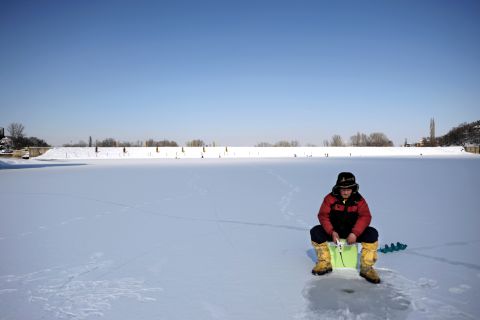 An ice fisherman waits for a catch on a frozen lake near Sofia on January 30.