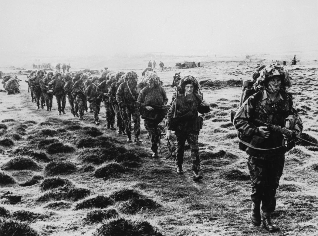 A line of British soldiers in camouflage advancing during the 1982 Falklands conflict. 