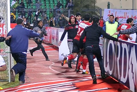 Al-Masry fans chase Al-Ahly players during riots that erupted after the football match.