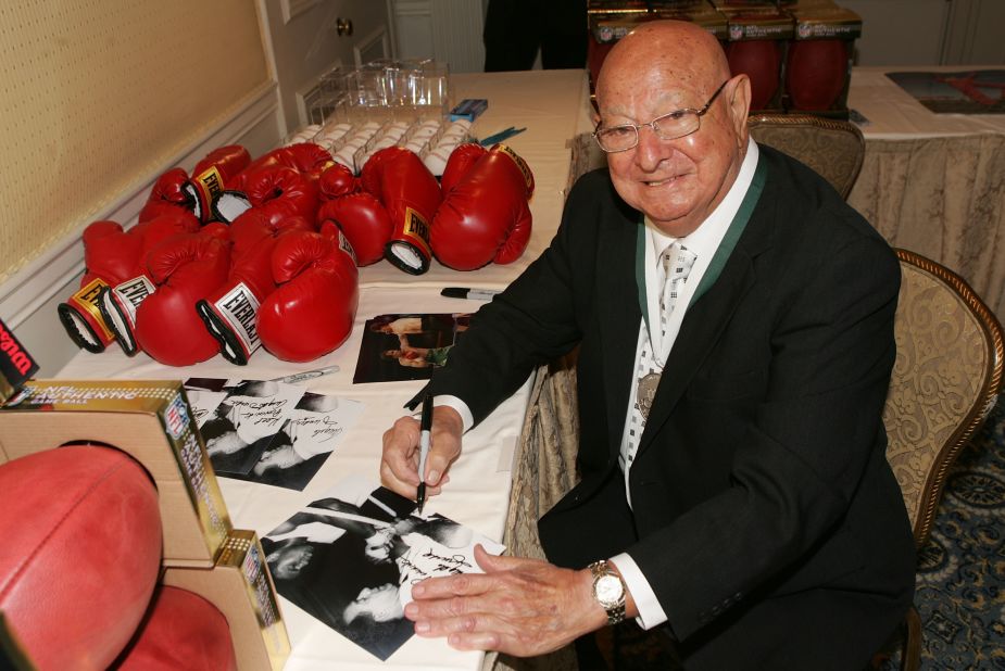 Dundee signs memorabilia at the 23rd Annual Great Sports Legends Dinner to Cure Paralysis in New York in September 2008. 