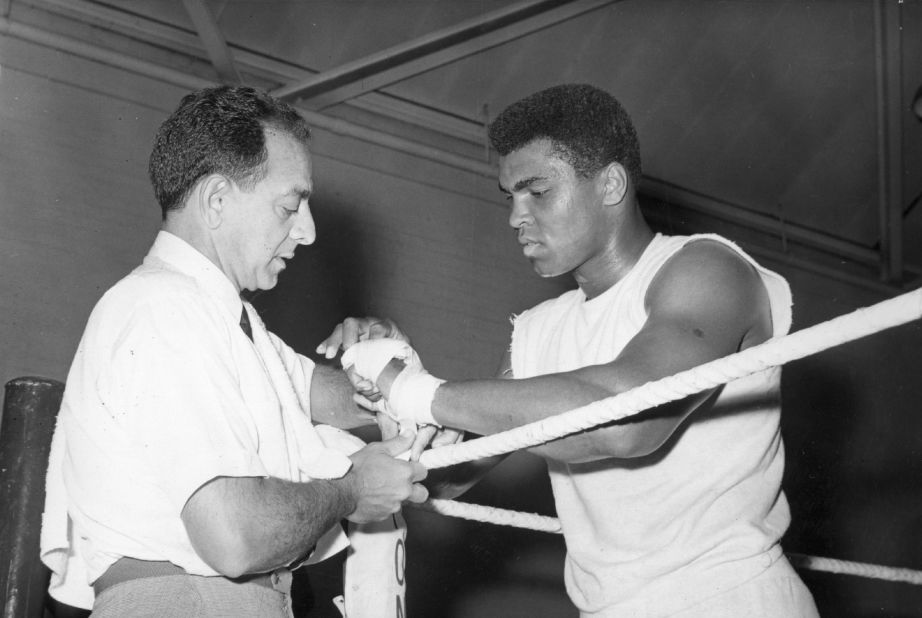 Angelo Dundee helped a young Cassius Clay transform himself into the world heavyweight champion. Here he tapes the renamed Muhammad Ali's hands at a training session ahead of a 1966 bout with British champion Henry Cooper.