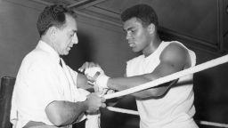 Angelo Dundee helped a young Cassius Clay transform himself into the world heavyweight champion. Here he tapes the renamed Muhammad Ali's hands at a training session ahead of a 1966 bout with British champion Henry Cooper.