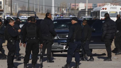 Municipal police officers in Ciudad Juarez, Mexico, collect evidence from a shooting that left colleague Julian Juarez Baena dead.
