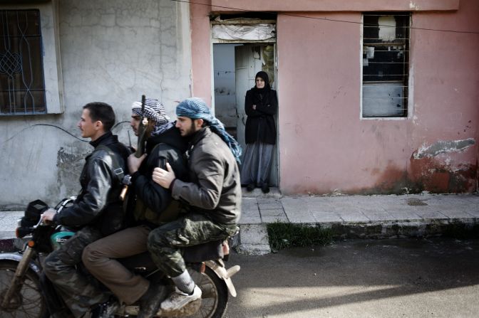 Free Syrian Army rebels ride a motorcycle through Al-Qusayr on January 28. A Corbis Images photographer spent several days in the town. His images offer a rare look at the combat in Syria, where access is limited.