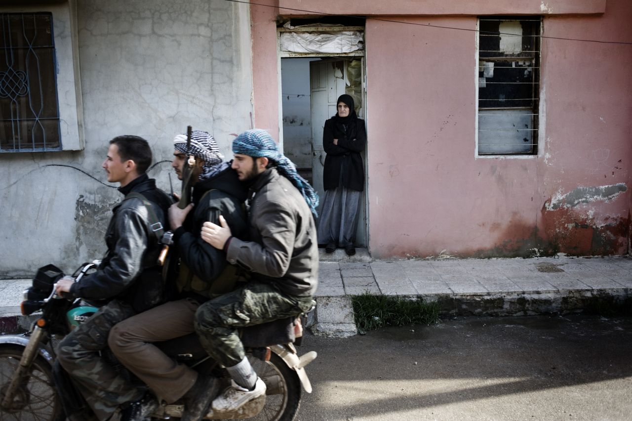 Free Syrian Army rebels ride a motorcycle through Al-Qusayr on January 28. A Corbis Images photographer spent several days in the town. His images offer a rare look at the combat in Syria, where access is limited.