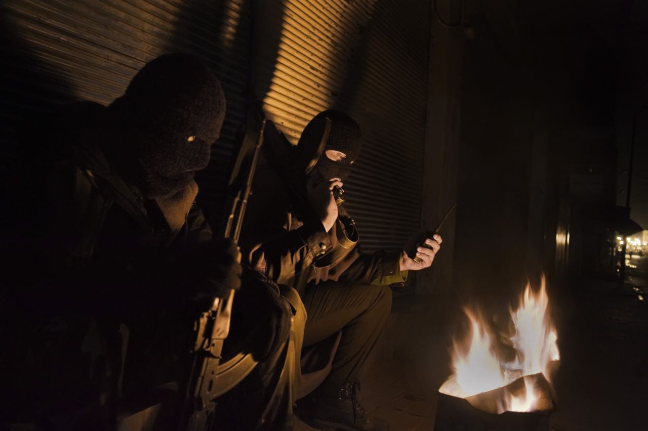 Free Syrian Army fighters stand guard at night in Al- Qusayr. The humanitarian crisis in Syria continues to worsen as armed rebels and government forces battle for control of towns and cities across the country.