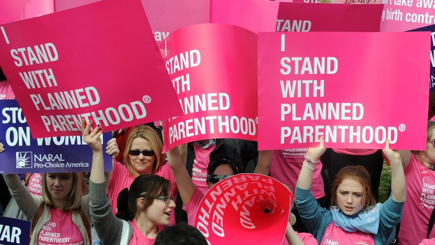 Participants shout slogans and display placards during a rally to "stand up for women's health" at the National Mall in Washington, DC, on April 7, 2011. Participants from across the country gathered in a show of support for Planned Parenthood, the family-planning group in the crosshairs of the budget battle blazing in Congress, where a federal shutdown is looming. AFP PHOTO/Jewel Samad (Photo credit should read JEWEL SAMAD/AFP/Getty Images)