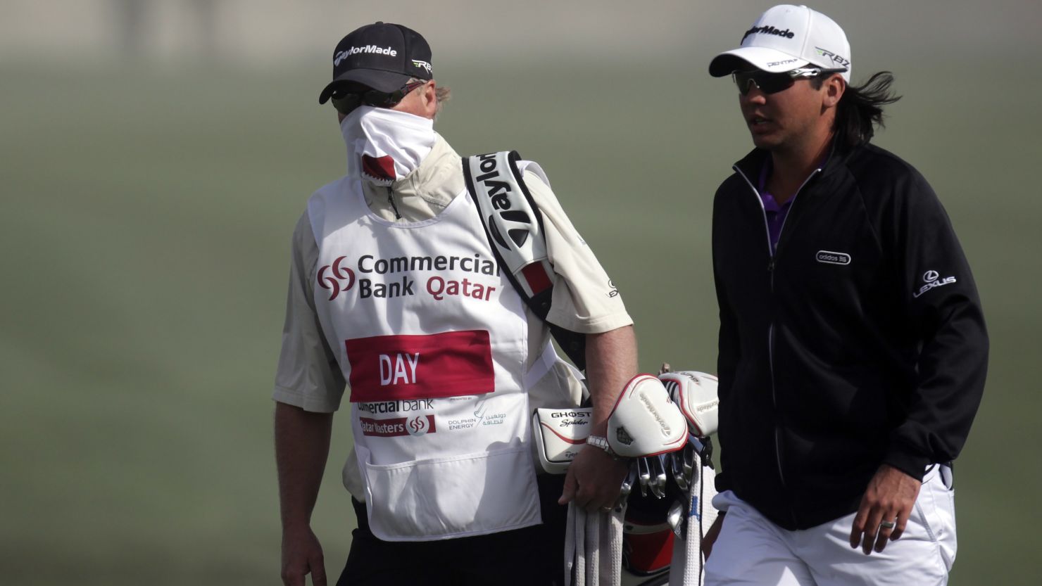 Australian Jason Day and his caddie leave the course after play was called off due to high winds.  