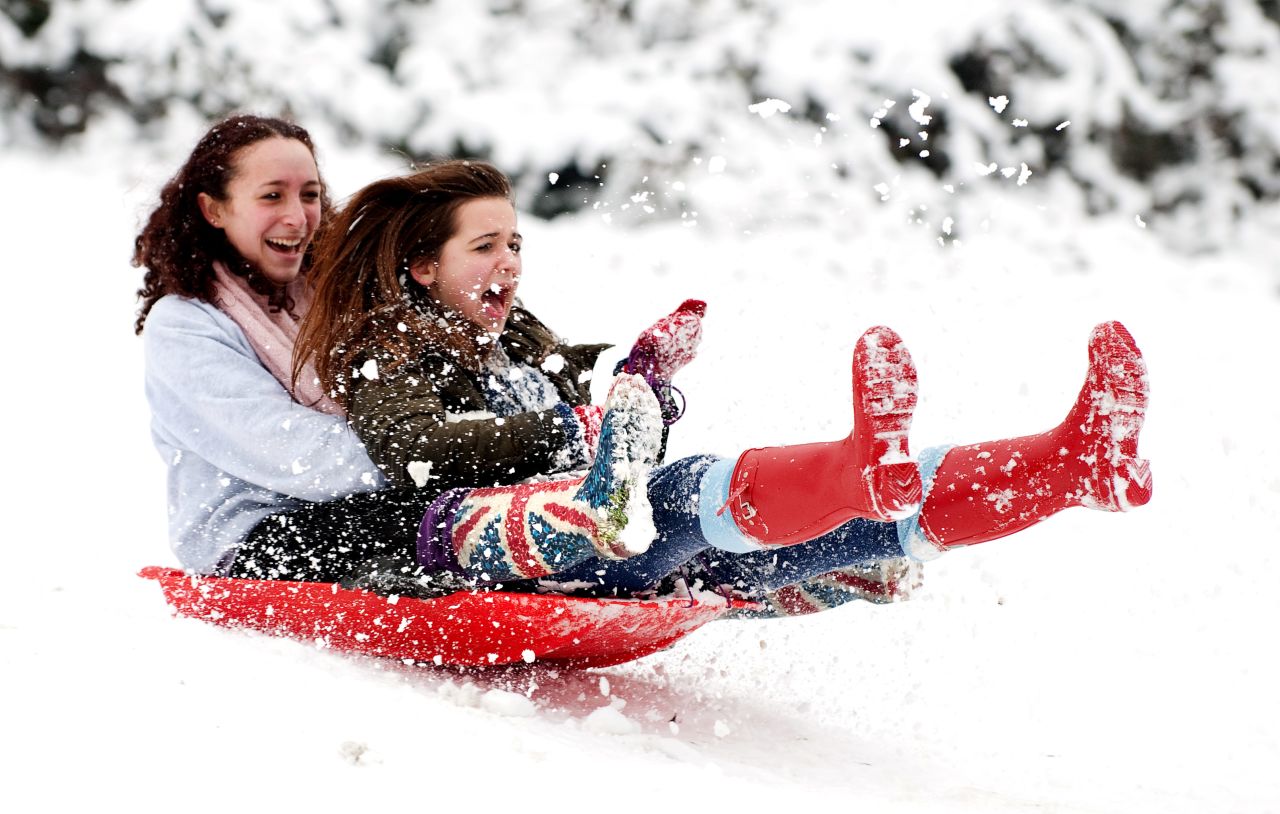 Two girls sled down the hill Sunday in London's Alexandra Park.