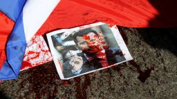 A picture of Syria's embattled President Bashar al-Assad sprayed with red paint lies on the ground next to a Russian flag about to be set on fire by protesters opposed to the Syrian regime during a demonstration outside the Russian embassy in Beirut on February 5.