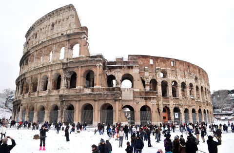 People stand in snow Saturday in front of the Colosseum in Rome.
