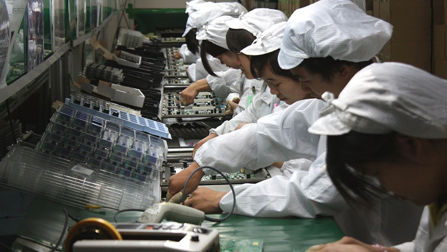 Workers on a production line at Foxconn's Longhua plant, which employs 300,000 people and makes products for Apple.