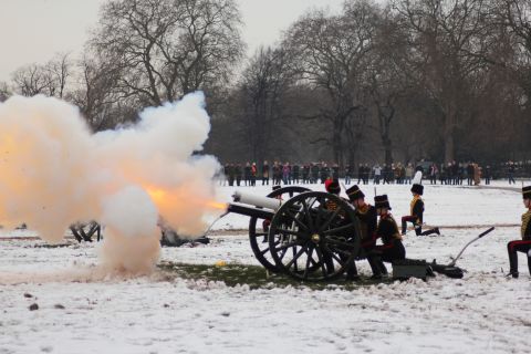 At the stroke of midday, the gunners commence the salute amidst a plume of smoke and muzzle flash. 