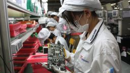 File photo workers on a production line at Foxconn's Longhua plant in Shenzhen, which employs 300,000.
