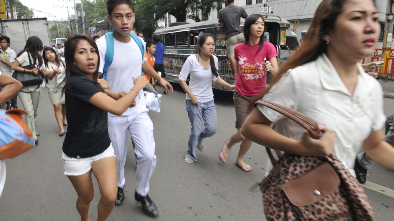 Residents scamper to safety after a 6.8 earthquake hit near Cebu City on Monday.