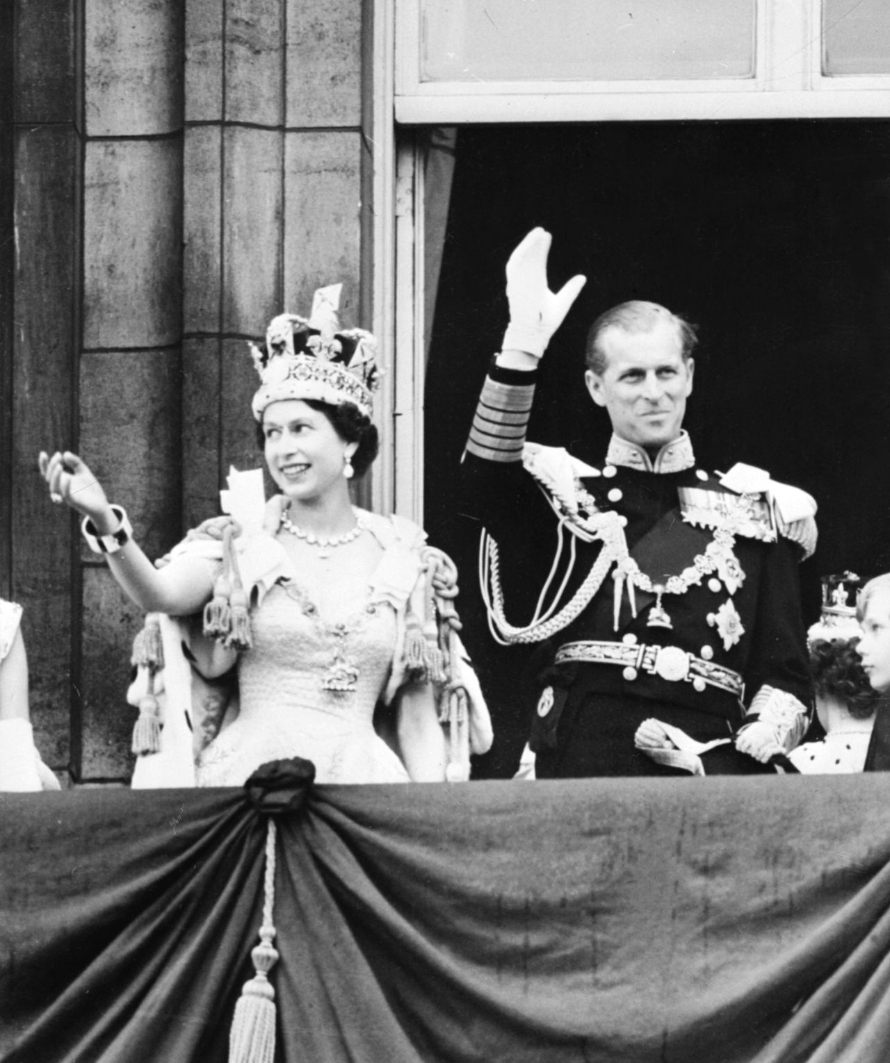 Queen Elizabeth II and Prince Philip wave to the crowd from Buckingham Palace on June 2, 1953.