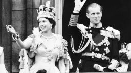 Queen Elizabeth II and Prince Philip wave to the crowd from Buckingham Palace on June 2, 1953.