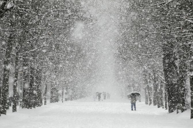 People walk through a park in Burgos as snow hits northern Spain on Sunday.