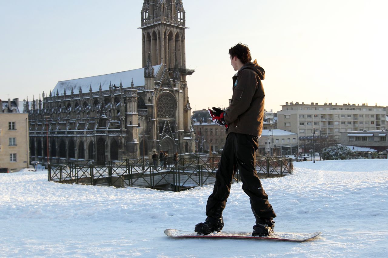 A man snowboards Sunday in Caen, France. Seventy-five French departments were under medium range (orange) alert for snow and ice Monday.