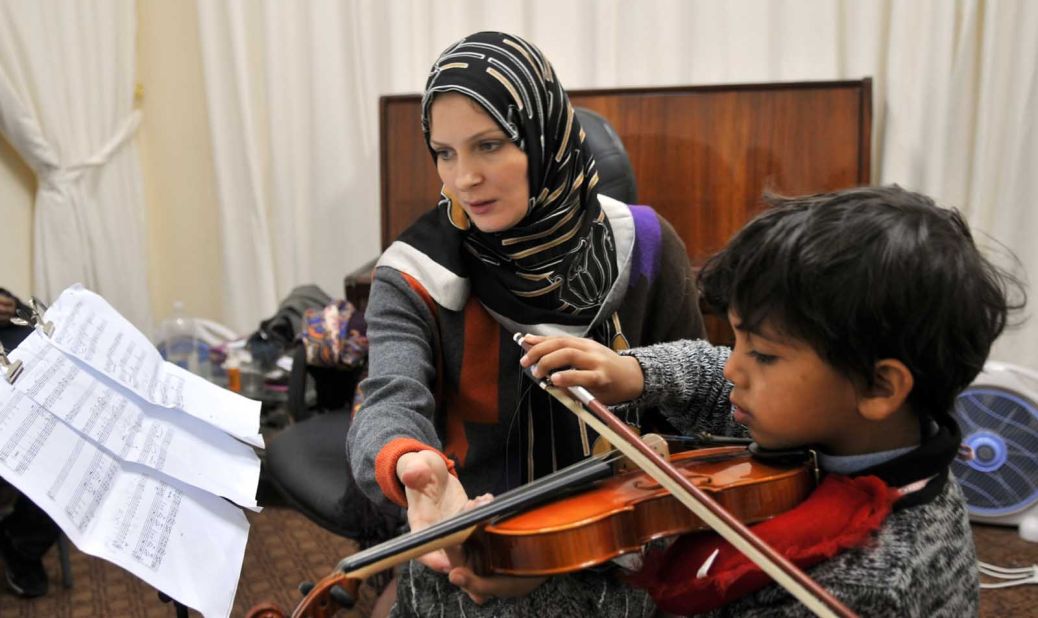 Violin teacher Elena Radwan teaching a young boy