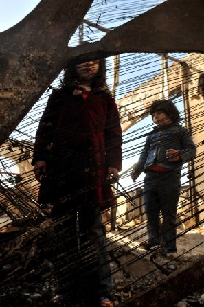 Child looks through a destroyed piano after the 2009 bombing of the school