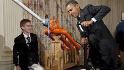 US President Barack Obama, alongside 14-year-old Joey Hudy of Phoenix, Arizona, using a pump to increase the pressure prior to launching a marshmallow from Hudy's 'Extreme Marshmallow Cannon' .