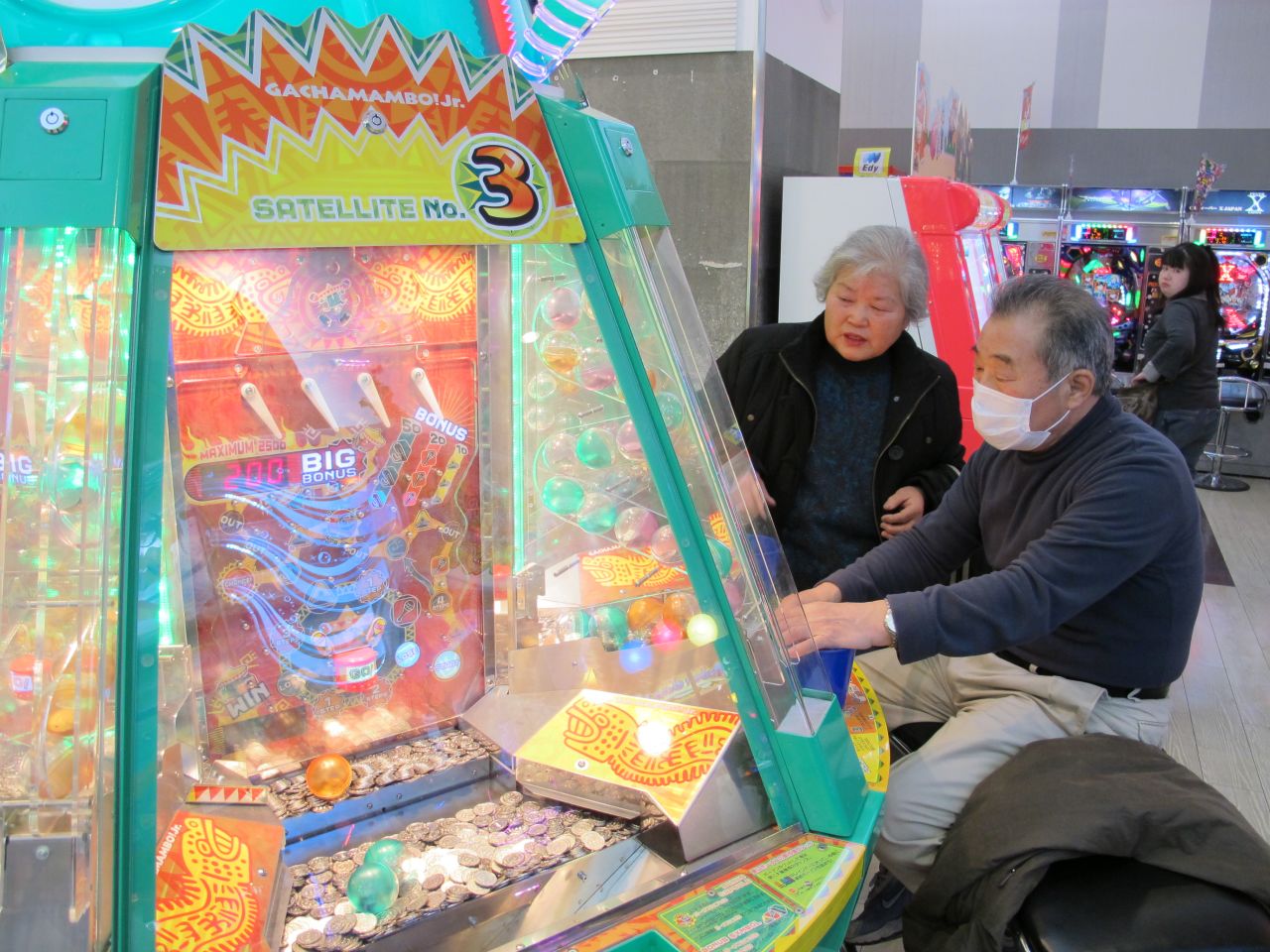 Tsuneko Kataoka, left, watches as another older gamer plays a game.