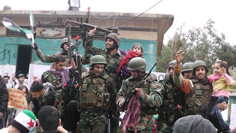 Syrian soldiers who defected join protesters in the al-Khaldiya neighborhood of the restive city of Homs last month.