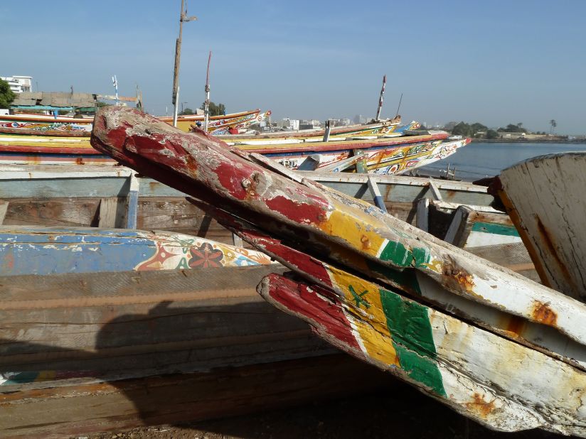 Aged wooden boats parking along the beaches of Dakar, weathered by time. 