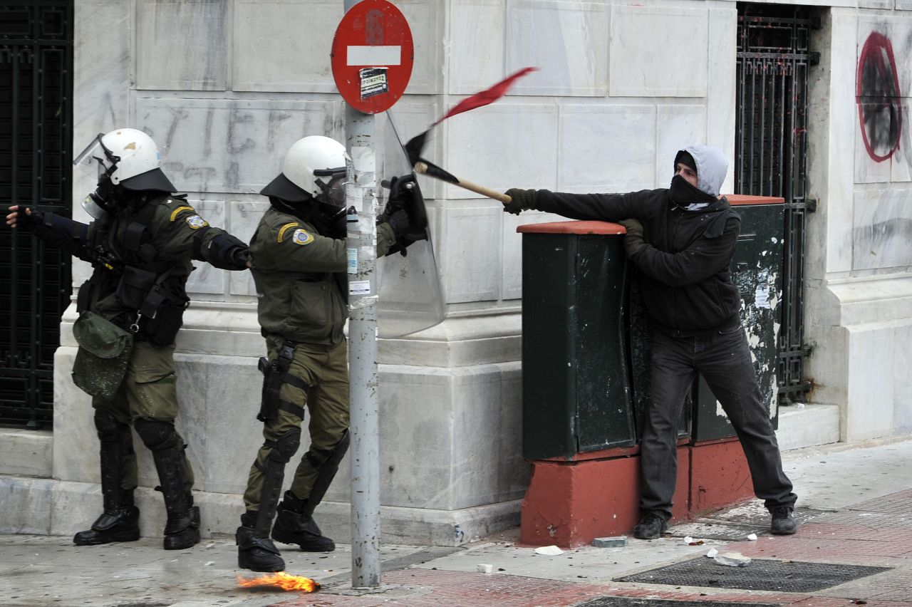Riot police clash with a demonstrator during the general strike in Athens on February 10, 2012. 