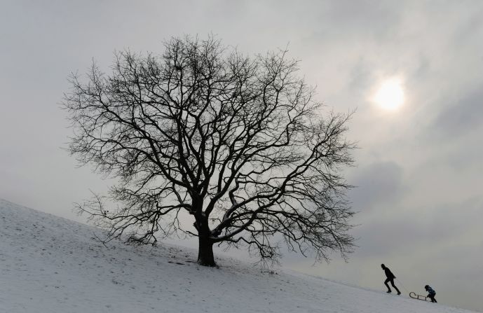 Bobsleigh riders walk at a small hill in the Olympic park in Munich, southern Germany, on February 7, 2012. 