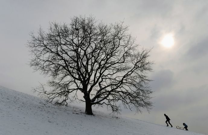Bobsleigh riders walk at a small hill in the Olympic park in Munich, southern Germany, on February 7, 2012.
