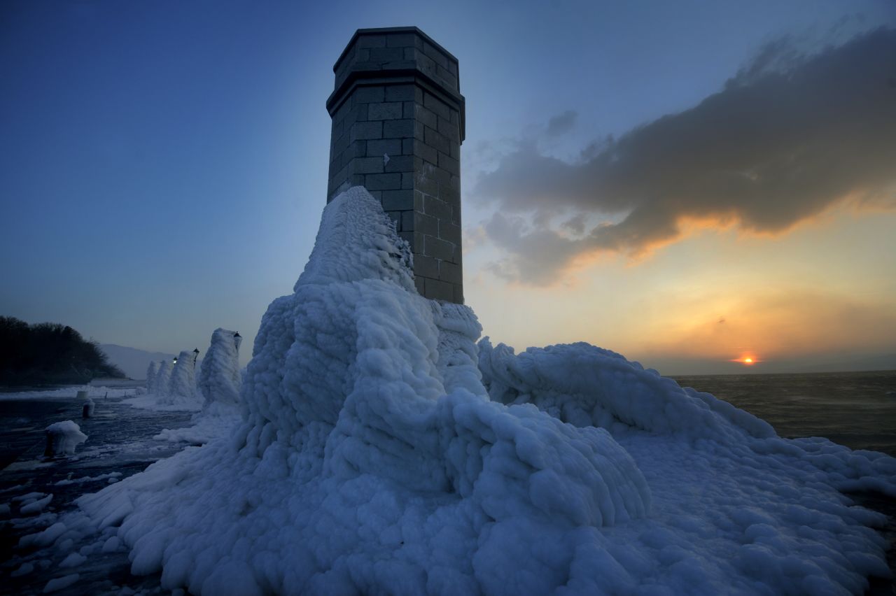 Lighthouse and lampposts are covered with heavy ice in central Adriatic Croatian port of Senj, some 200 kilometres from Zagreb, as the sun sets on February 8, 2012. There are more than 100 villages still trapped by snow in remote, mountain parts in Croatia.