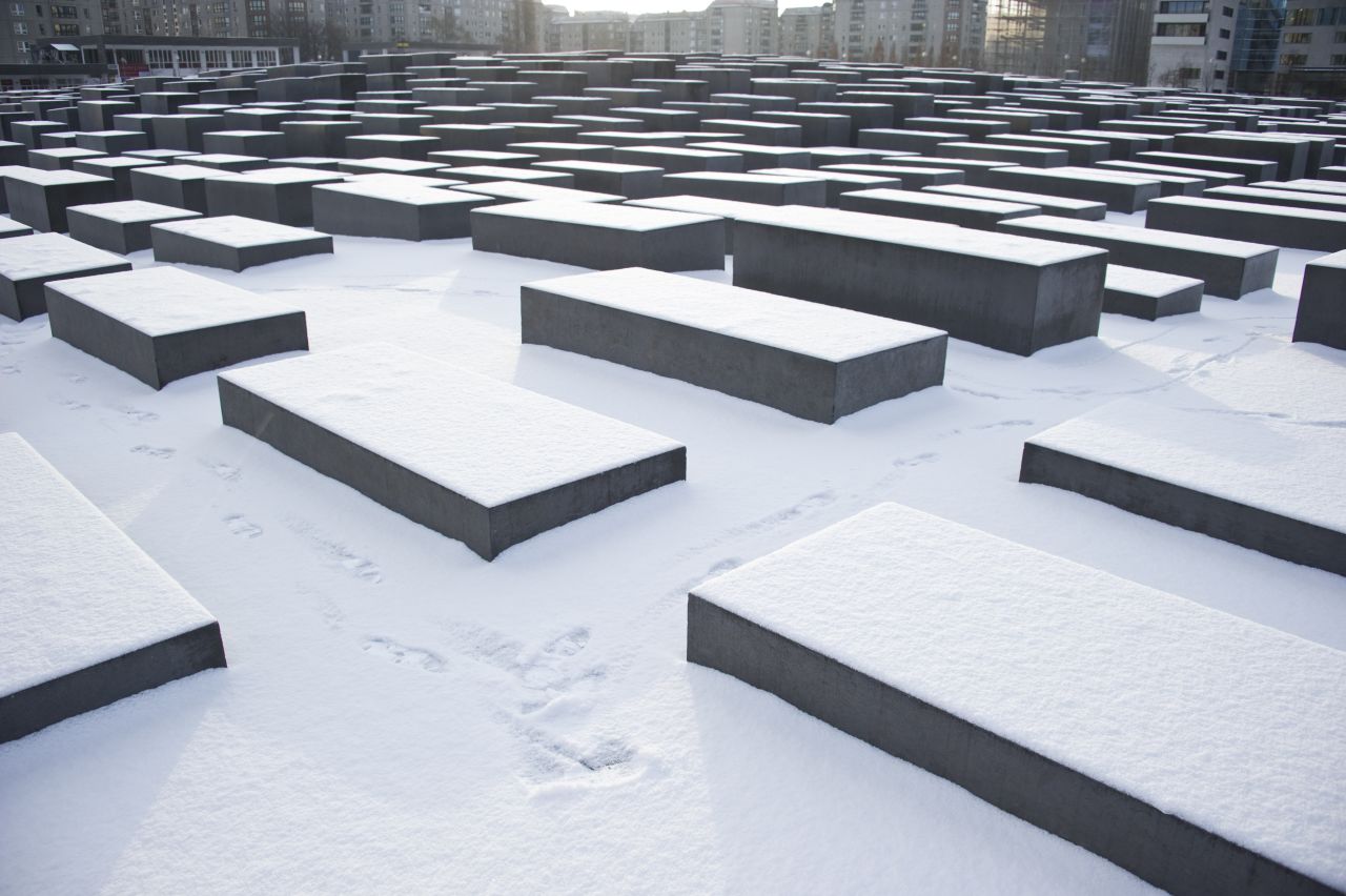 A man walks past concrete steles of the Monument for the Murdered Jews of Europe after fresh snowfall on February 9, 2012 in Berlin. 