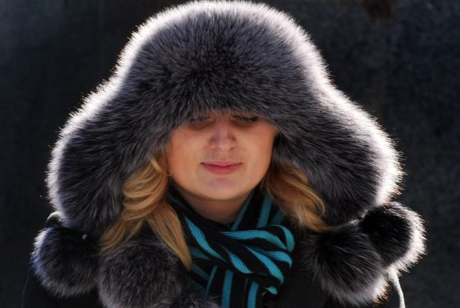 A woman sporting a fur hat walks in the center of Ukrainian capital of Kiev on February 9, 2012. Helicopters ferried food and medicine to iced-in villagers Wednesday as the cold snap tightened its frigid grip on the continent.