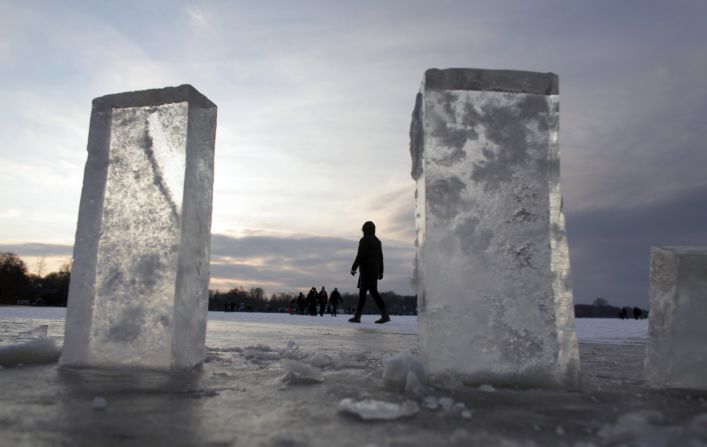 People walk on the frozen lake Zwischenahner Meer in Bad Zwischenahn, near Oldenburg, northern Germany, where blocks of ice have been cut out.