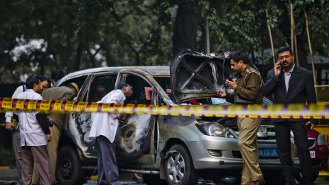 Police and forensic officers examine a damaged Israeli embassy vehicle after an explosion on February 13, 2012 in New Delhi, India