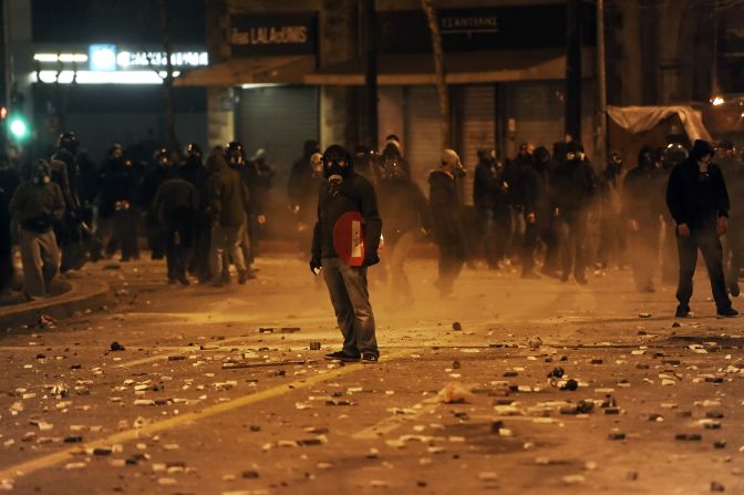 A demonstrator holds a traffic sign during clashes between protesters and riot police near the Greek parliament in Athens on February 12.
