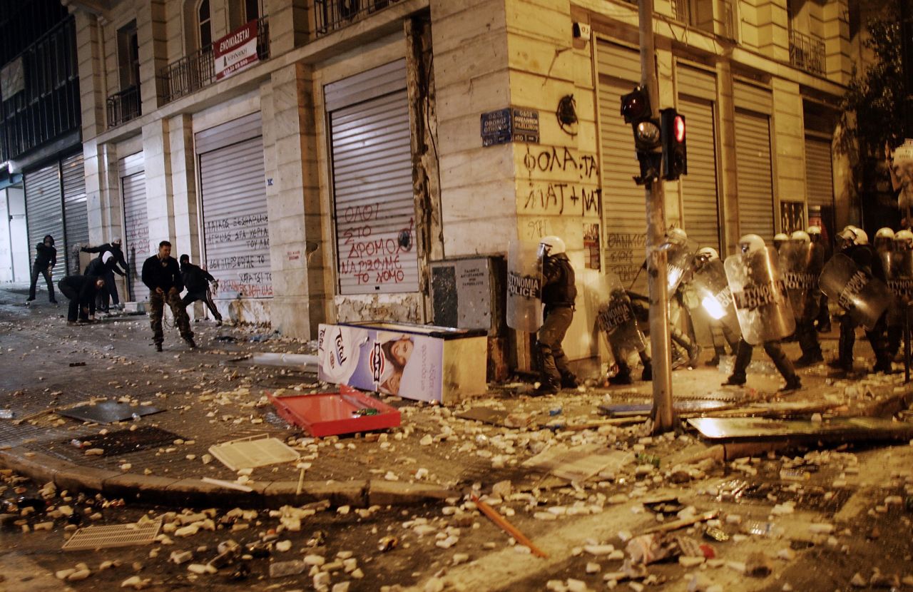 Demonstrators throw projectiles to riot police during violent protests in central Athens 