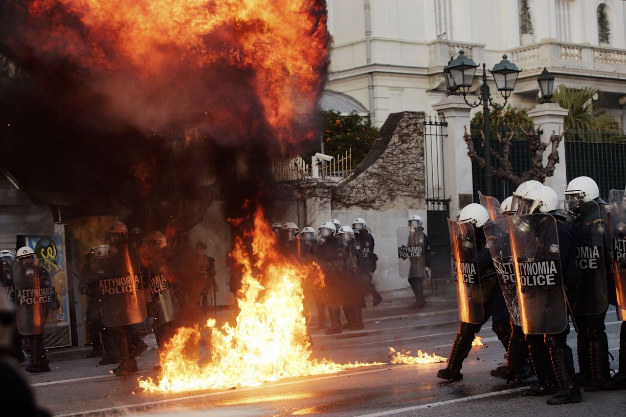 Demonstrators throw fire bombs to riot police during violent protests in central Athens. Thousands took the streets as the Greek parliament prepared to vote on a new and deeply unpopular EU/IMF austerity deal, to secure a 130 billion euro bailout, aimed at saving Greece from bankruptcy and what Prime Minister Lucas Papademos warned would be "uncontrollable economic chaos".  