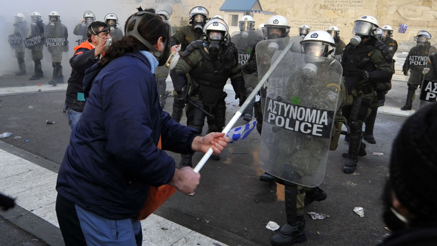 Protesters clash with riot police in front of the Greek Parliament in Athens on February 12, 2012.