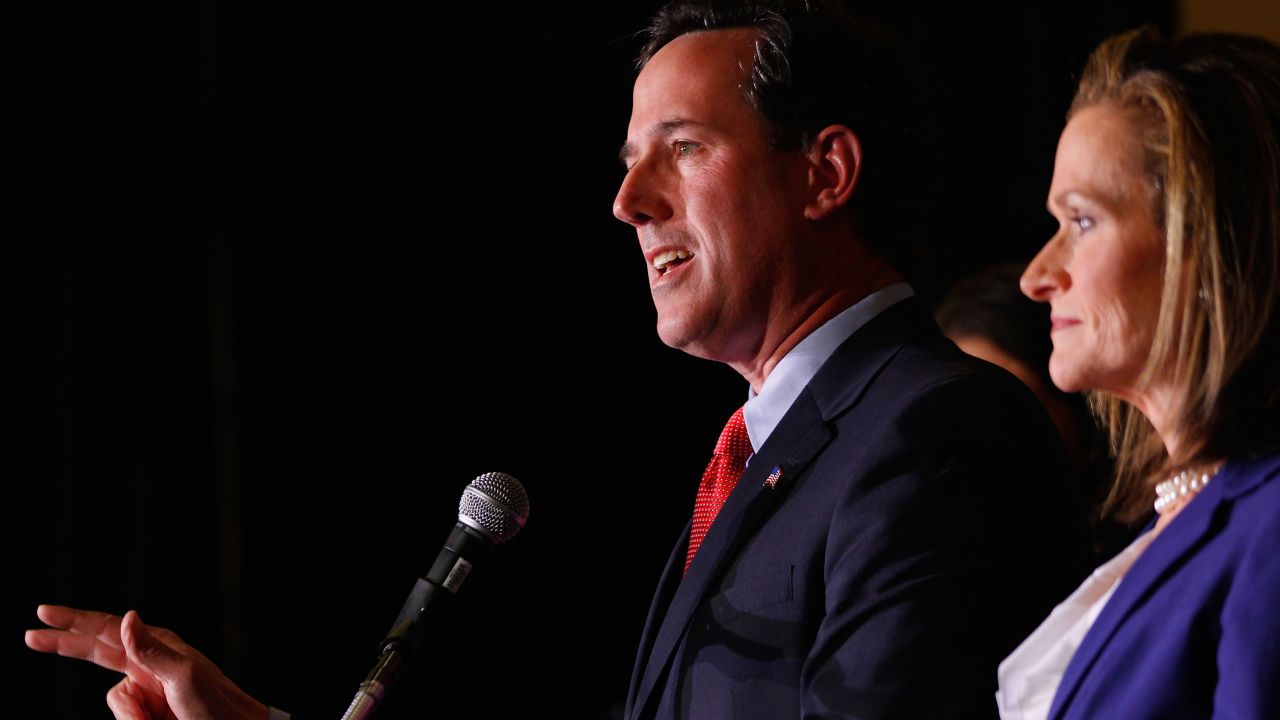 Rick Santorum speaks to supporters as his wife, Karen, looks on. Santorum says Karen wrote parts of 2005 book.