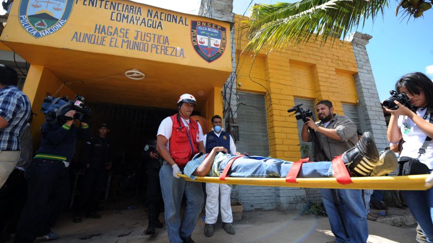 Honduran Red Cross personnel transport an injured inmate out of the National Prison compound in Comayagua, Honduras, on February 15, 2012.